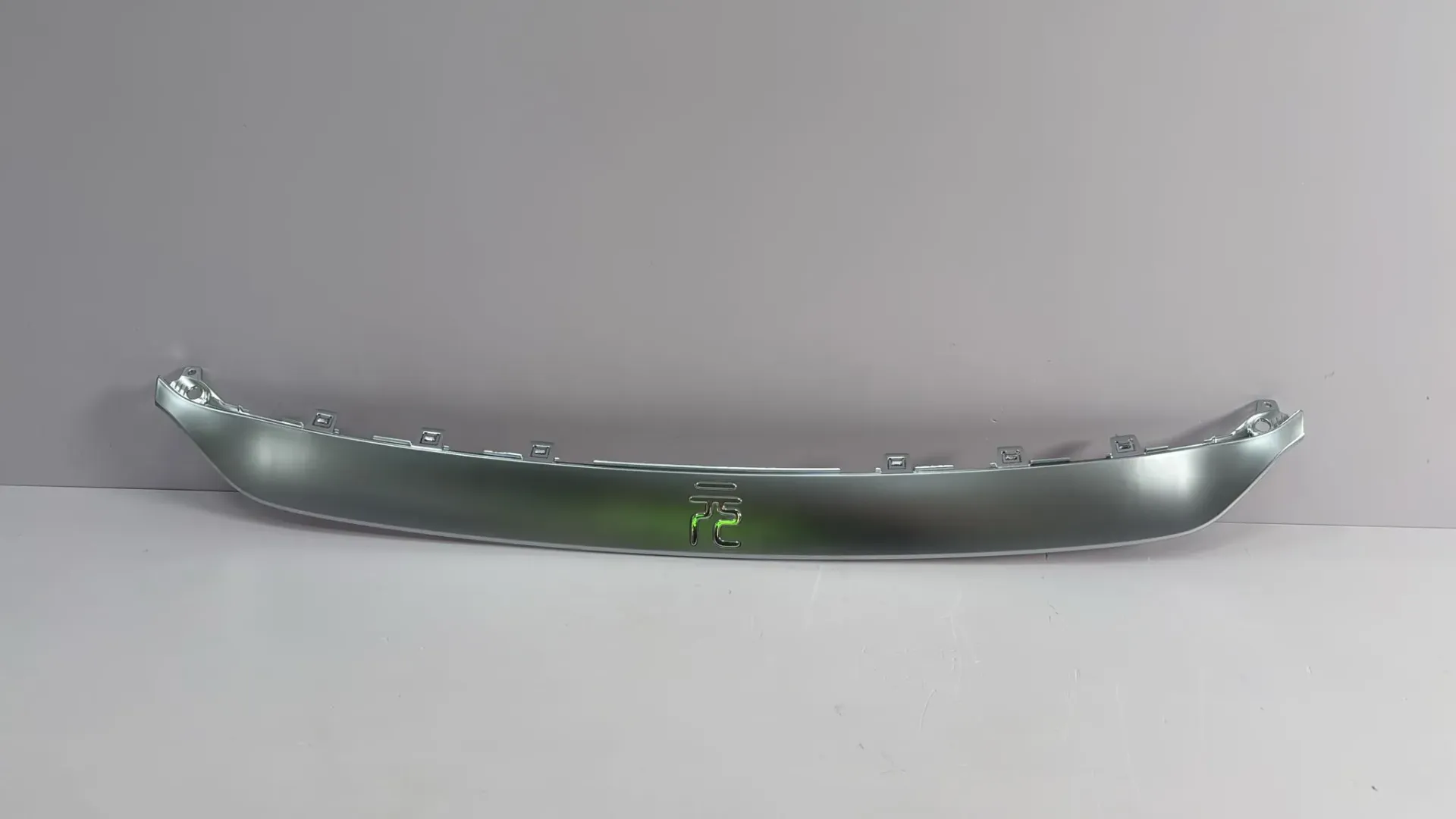 [SC2E-2803114/92-C] Pjesë dekorative e logos në pjesën e sipërme të parakolpit përpara M00000